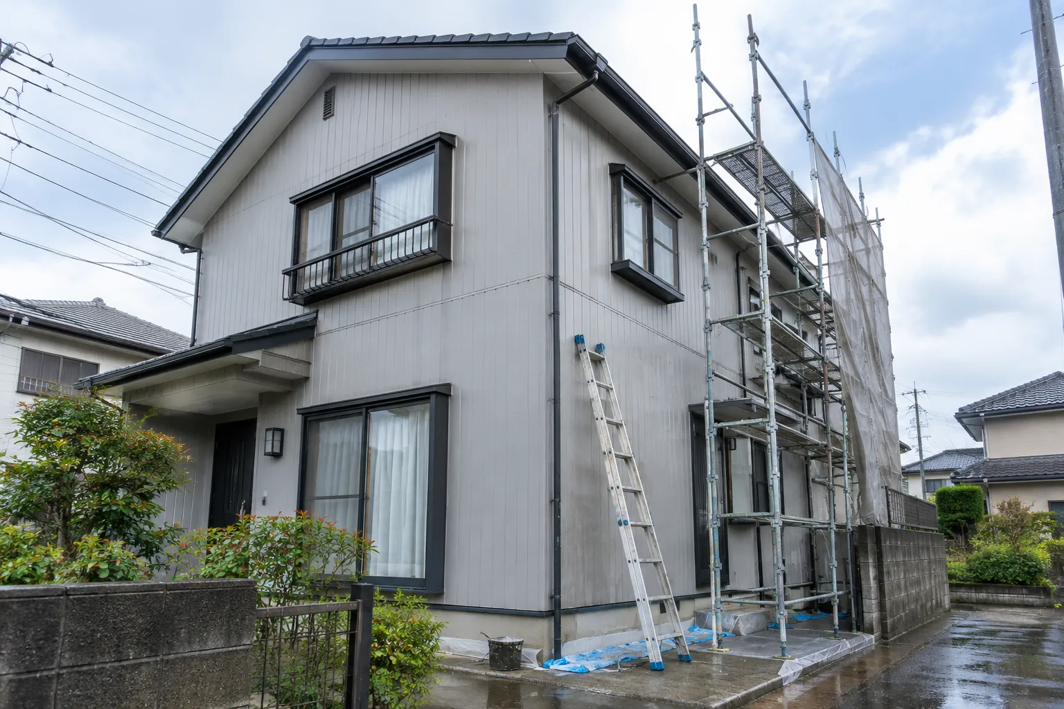 住宅の外壁を塗り替えている様子のイメージ（生成画像）